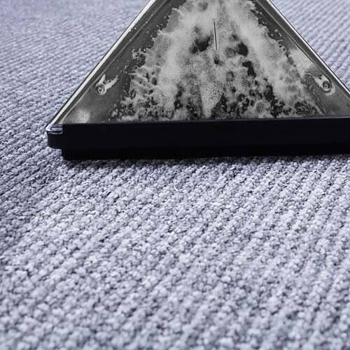 Steam cleaning wand extracting dirt from a blue carpet